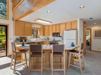This spacious kitchen features warm, natural wood cabinetry and a large island with seating, perfect for casual dining or entertaining.
