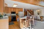 This spacious kitchen features warm oak cabinetry and a convenient island with bar seating, perfect for casual dining or entertaining.
