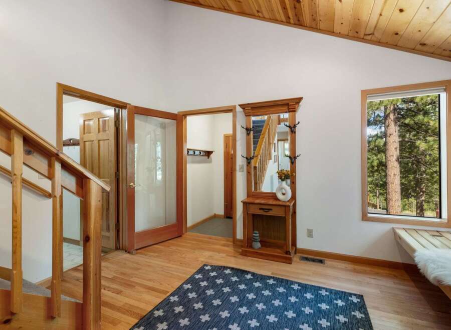 Step into this inviting entryway featuring a charming wooden hall tree with a mirror, perfect for storing essentials.