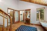 Step into this inviting entryway featuring a charming wooden hall tree with a mirror, perfect for storing essentials.