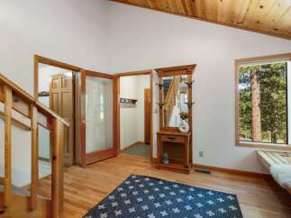 Step into this inviting entryway featuring a charming wooden hall tree with a mirror, perfect for storing essentials.