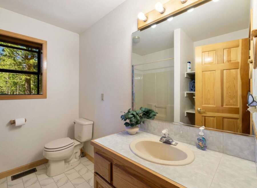 This charming bathroom features a comfortable toilet and a spacious vanity with a sink, perfect for everyday routines.
