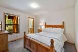 This charming bedroom features a cozy wooden bed with crisp white linens, perfect for a restful night's sleep.