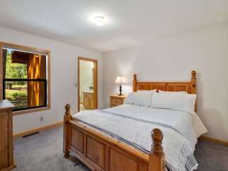 This charming bedroom features a cozy wooden bed with crisp white linens, perfect for a restful night's sleep.