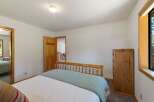 This cozy bedroom features a comfortable bed with a light blue throw, perfect for relaxing.