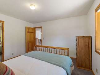 This cozy bedroom features a comfortable bed with a light blue throw, perfect for relaxing.