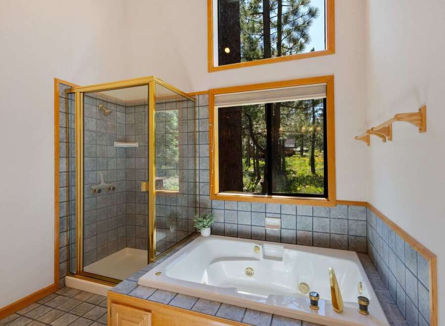 Experience ultimate relaxation in this luxurious bathroom featuring a spacious jetted tub and a separate glass-enclosed shower.