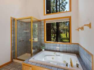 Experience ultimate relaxation in this luxurious bathroom featuring a spacious jetted tub and a separate glass-enclosed shower.