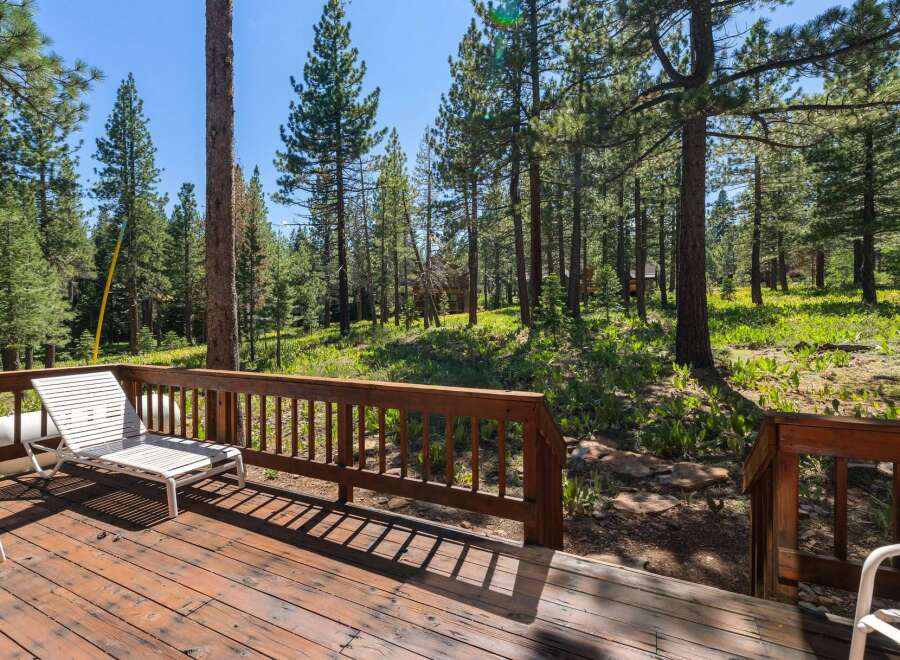 Enjoy the serene mountain lifestyle from this charming deck, nestled amongst tall pine trees.