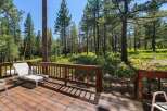 Enjoy the serene mountain lifestyle from this charming deck, nestled amongst tall pine trees.