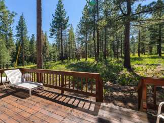 Enjoy the serene mountain lifestyle from this charming deck, nestled amongst tall pine trees.