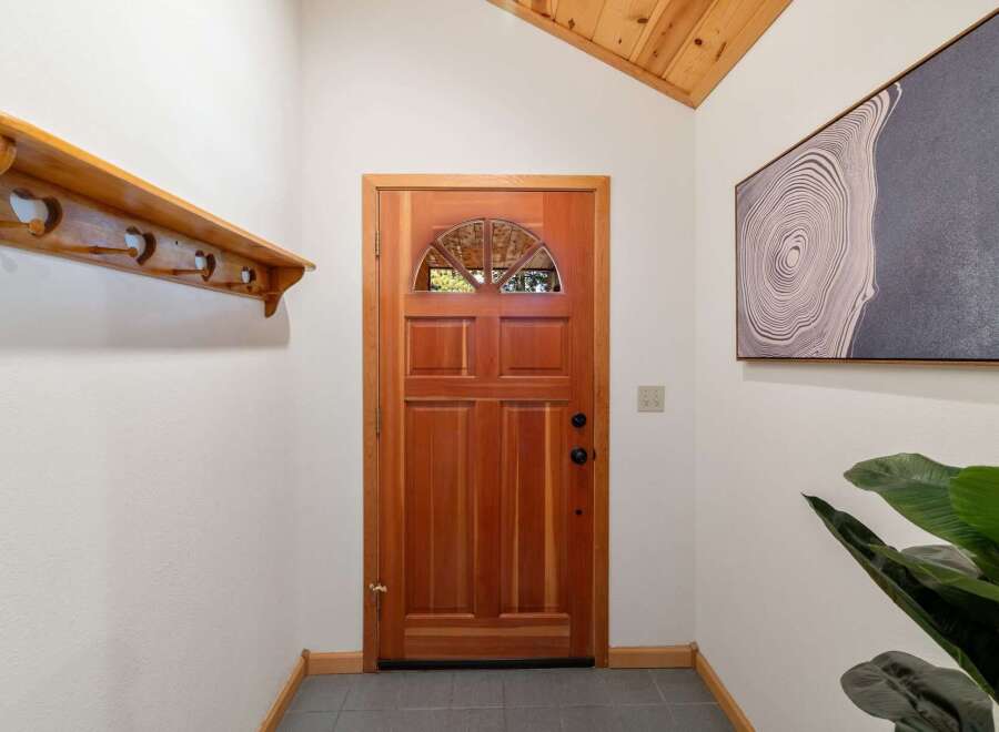 Step into this welcoming entryway featuring a beautiful wooden door with a semicircular glass pane, perfect for natural light.