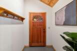 Step into this welcoming entryway featuring a beautiful wooden door with a semicircular glass pane, perfect for natural light.