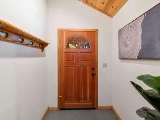 Step into this welcoming entryway featuring a beautiful wooden door with a semicircular glass pane, perfect for natural light.