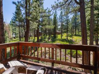 Enjoy the serene mountain lifestyle from this charming cabin deck, offering breathtaking views of the surrounding pine forest.