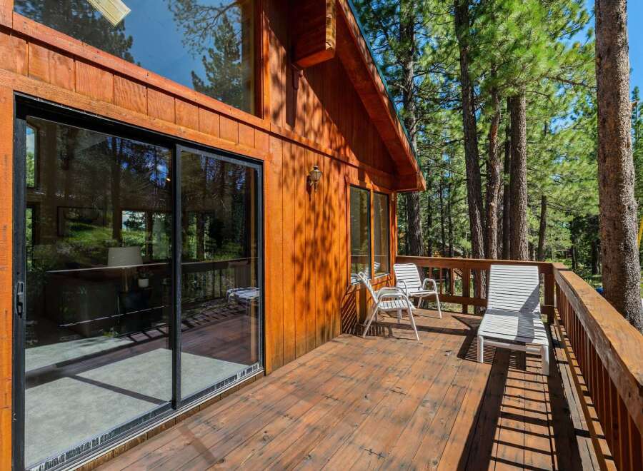 Enjoy the serene mountain lifestyle from this charming wooden cabin featuring a spacious deck perfect for outdoor relaxation.