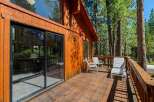 Enjoy the serene mountain lifestyle from this charming wooden cabin featuring a spacious deck perfect for outdoor relaxation.