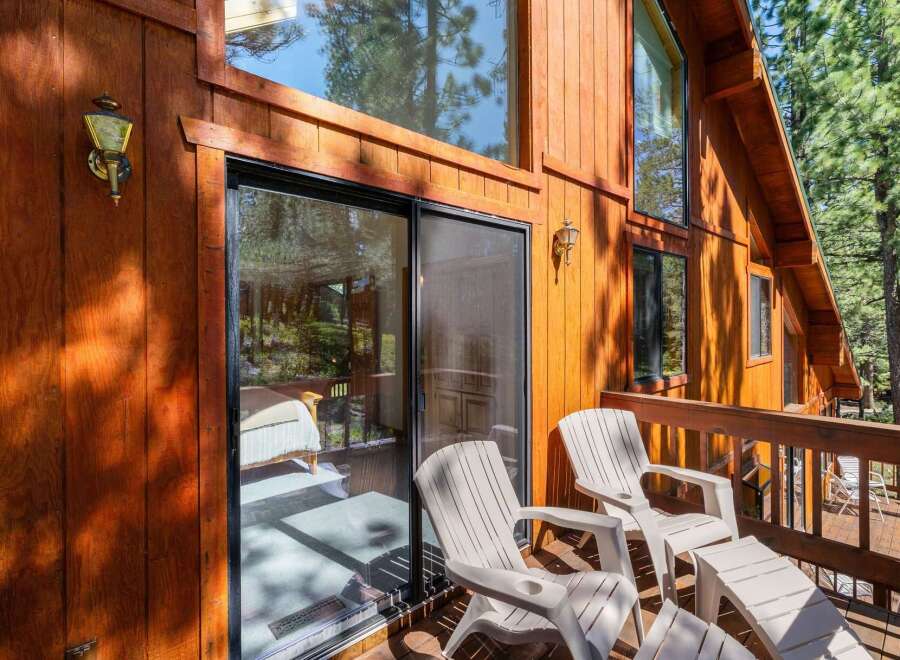 Enjoy the serene mountain views from this charming cabin's private deck, complete with comfortable seating and a sliding glass door for easy access.