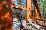 Enjoy the serene mountain views from this charming cabin's private deck, complete with comfortable seating and a sliding glass door for easy access.
