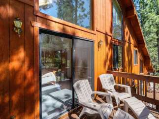 Enjoy the serene mountain views from this charming cabin's private deck, complete with comfortable seating and a sliding glass door for easy access.