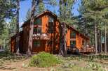 Nestled amidst tall pine trees, this stunning wooden A-frame home offers a serene retreat.