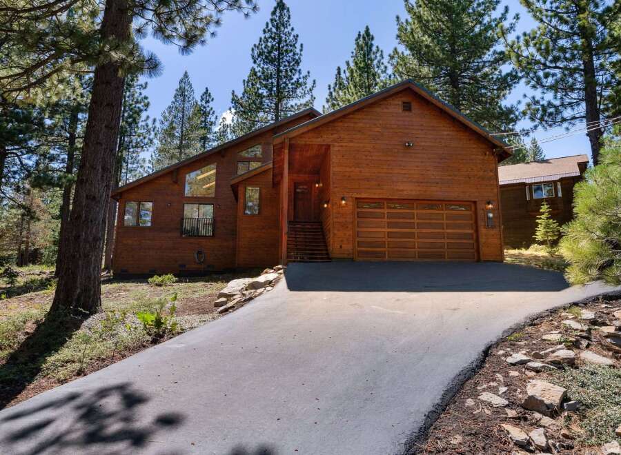 Discover this stunning wooden A-frame home nestled amongst tall pine trees, offering a serene mountain retreat.