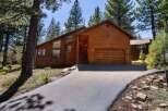 Discover this stunning wooden A-frame home nestled amongst tall pine trees, offering a serene mountain retreat.