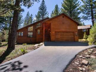 Discover this stunning wooden A-frame home nestled amongst tall pine trees, offering a serene mountain retreat.