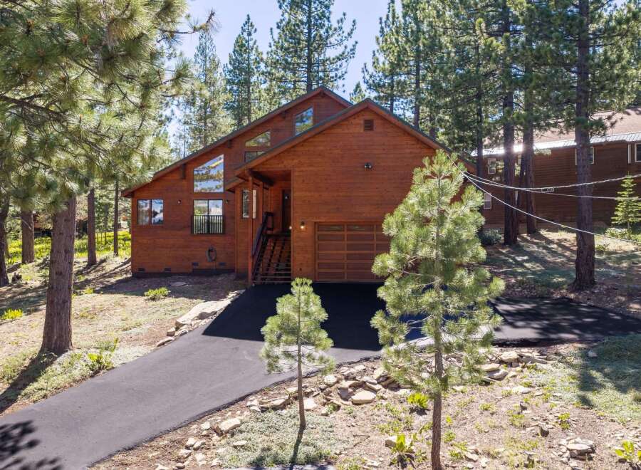 Nestled amongst tall pine trees, this stunning wooden home offers a serene mountain retreat.