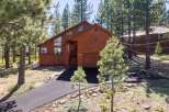 Nestled amongst tall pine trees, this stunning wooden home offers a serene mountain retreat.
