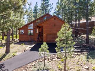 Nestled amongst tall pine trees, this stunning wooden home offers a serene mountain retreat.