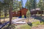 Nestled among tall pine trees, this stunning wooden home offers a serene mountain retreat.