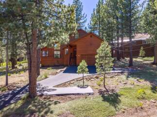 Nestled among tall pine trees, this stunning wooden home offers a serene mountain retreat.