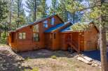 Nestled amongst tall pine trees, this stunning wooden home offers a rustic yet modern aesthetic.