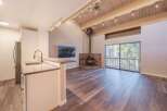 Experience cozy living in this charming space featuring a rustic stone fireplace and a modern kitchen island with a sleek faucet.