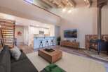 Experience modern living in this stunning open-concept space featuring a vaulted ceiling with exposed beams and a cozy fireplace.
