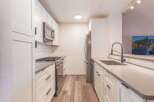 Discover this beautifully renovated kitchen, featuring sleek white cabinetry and modern stainless steel appliances, including a gas range and microwave.