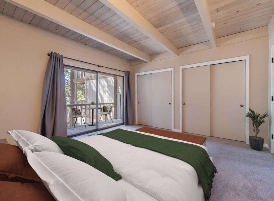 Step into this charming bedroom featuring a cozy bed with plush pillows and a stylish green throw.