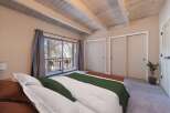 Step into this charming bedroom featuring a cozy bed with plush pillows and a stylish green throw.