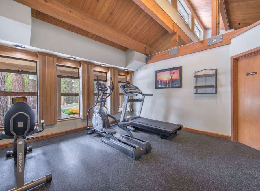 Stay active in this well-equipped home gym featuring a treadmill and elliptical machine, perfect for your daily workouts.