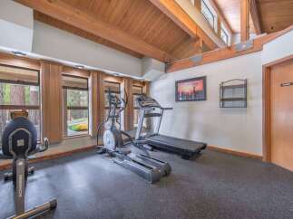 Stay active in this well-equipped home gym featuring a treadmill and elliptical machine, perfect for your daily workouts.