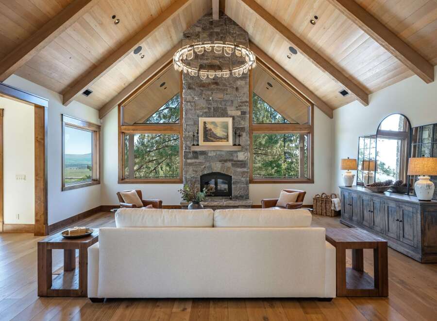 Experience luxury mountain living in this stunning great room, featuring a soaring vaulted wood-beamed ceiling and a magnificent stone fireplace.