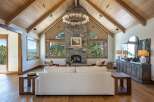 Experience luxury mountain living in this stunning great room, featuring a soaring vaulted wood-beamed ceiling and a magnificent stone fireplace.