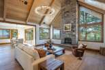 Experience luxury mountain living in this stunning great room featuring a soaring vaulted wood-beamed ceiling and a magnificent floor-to-ceiling stone fireplace.