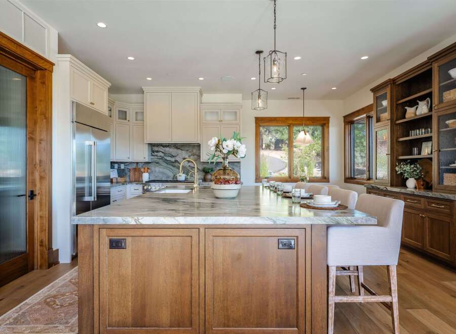 Experience luxury in this stunning kitchen featuring a large marble island with ample seating, perfect for entertaining.