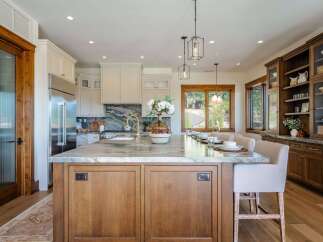 Experience luxury in this stunning kitchen featuring a large marble island with ample seating, perfect for entertaining.