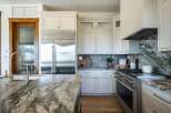 Experience luxury in this stunning kitchen, featuring a large island with a dramatic marble countertop and a matching backsplash.
