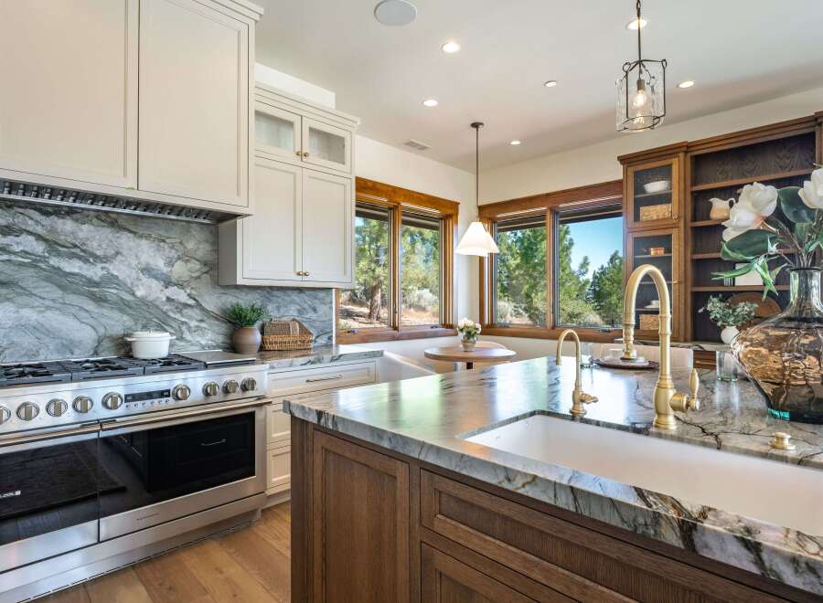 Experience luxury in this stunning kitchen, featuring a professional-grade stainless steel range and a dramatic marble backsplash.