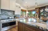 Experience luxury in this stunning kitchen, featuring a professional-grade stainless steel range and a dramatic marble backsplash.
