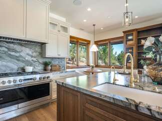 Experience luxury in this stunning kitchen, featuring a professional-grade stainless steel range and a dramatic marble backsplash.